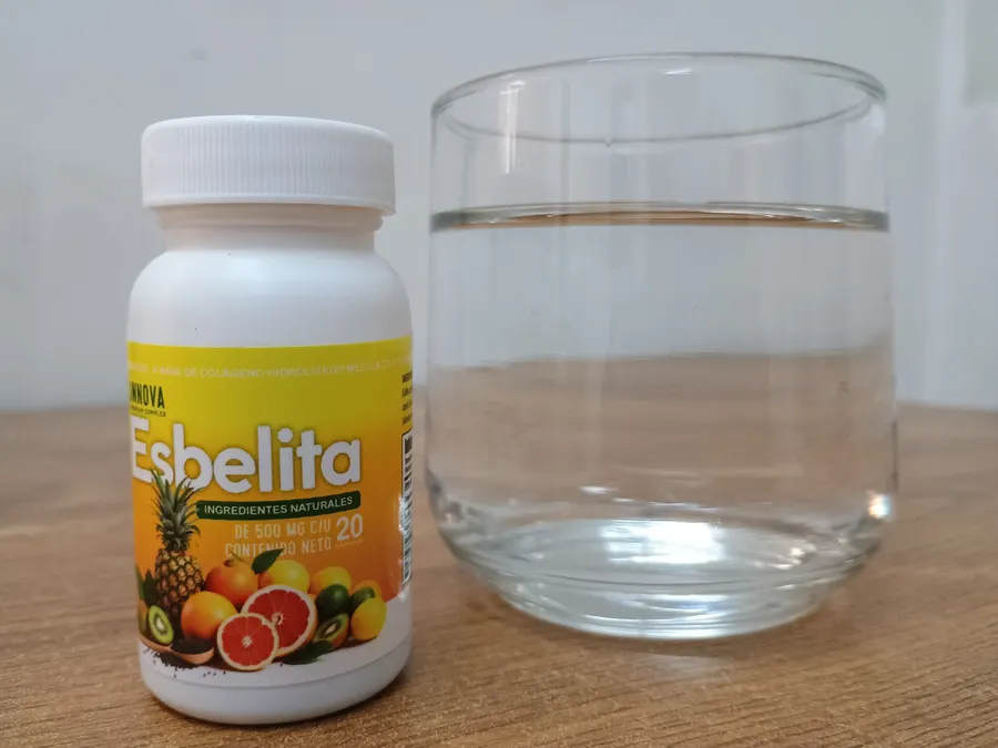 Frasco de Esbelita junto a un vaso de agua